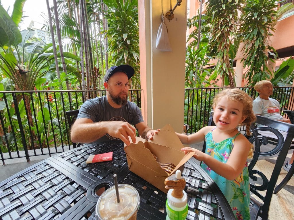 Father and daughter enjoying bakery items at the Royal Hawaiian Bakery.