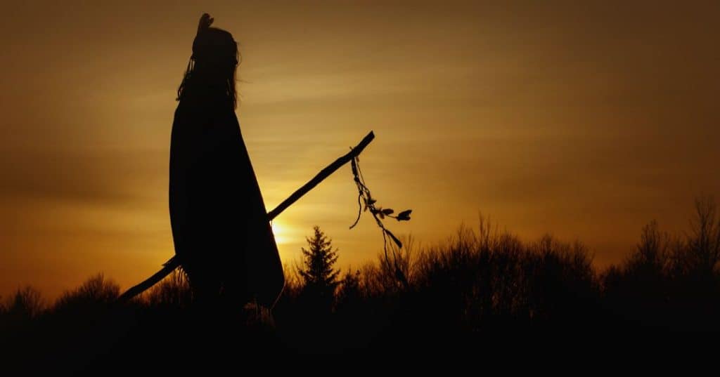 Native American silhouetted by the setting sun.