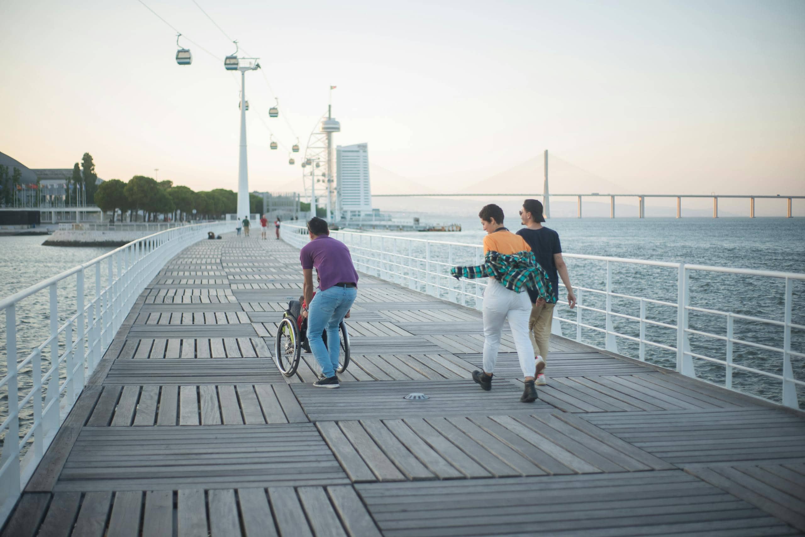 People Walking on the Bridge Near the Sea. Featured image for Living with a Disability Page