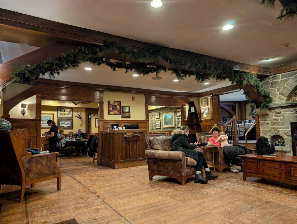 Cozy interior of Timberlake's Restaurant at Chetola Resort, featuring rustic wood accents, stone fireplace, and comfortable seating areas where guests enjoy conversations and dining.