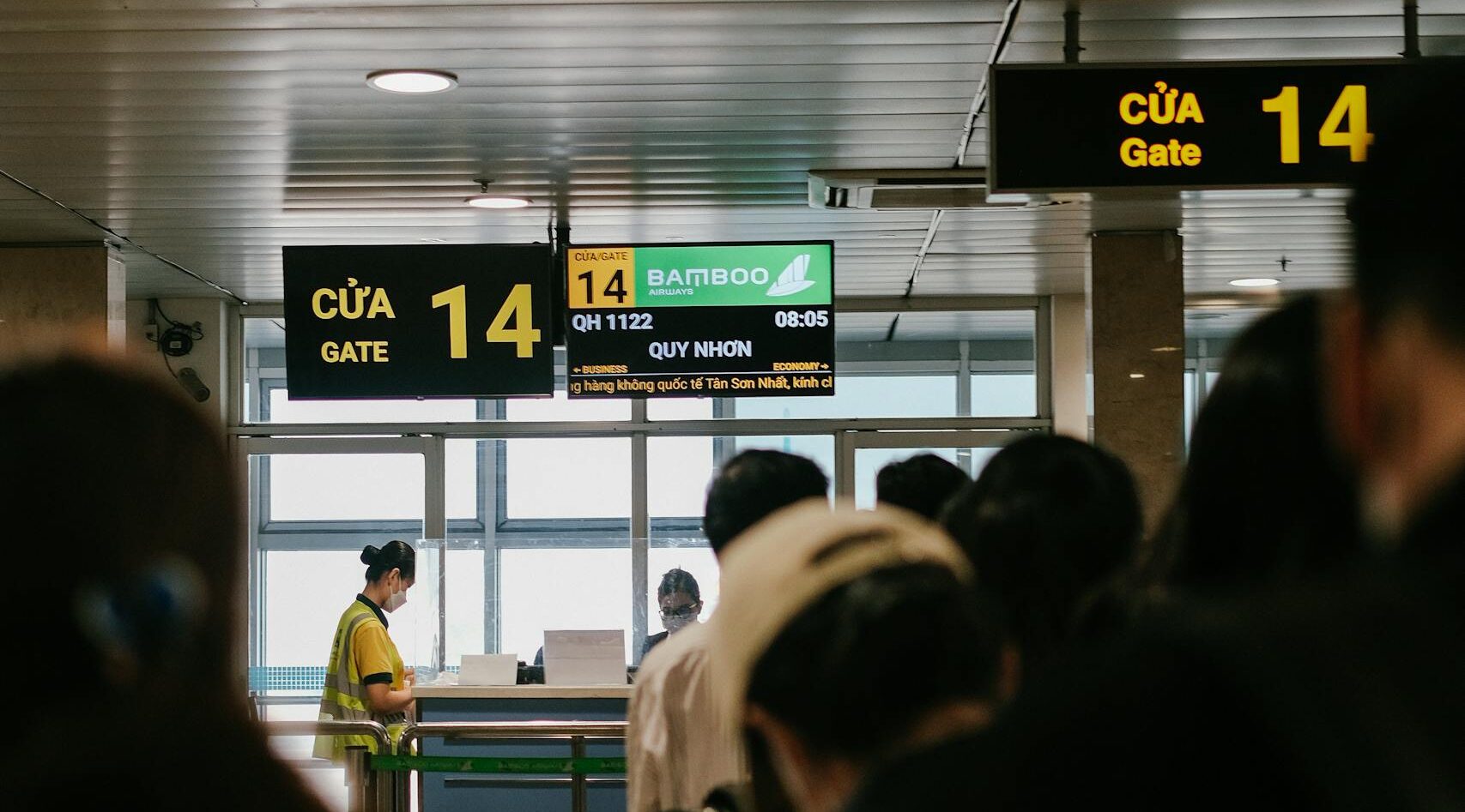 People standing in line at an airport gate, waiting to board a flight.