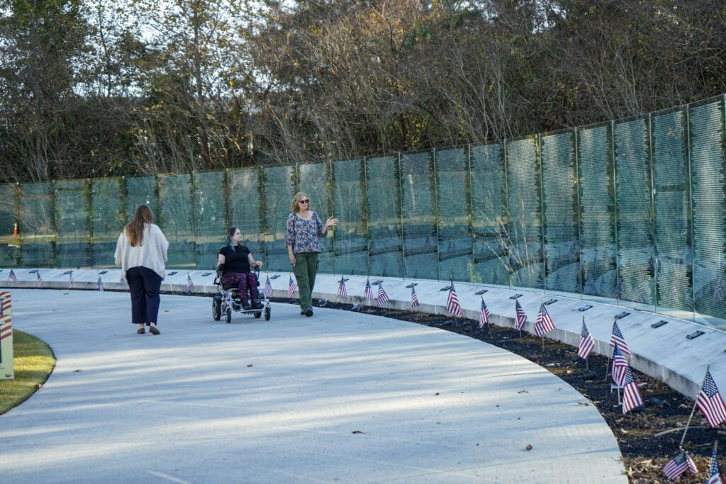 Three women walking together exploring the Vietnam Memorial at Lejeune Memorial Gardens in Jacksonville, NC.